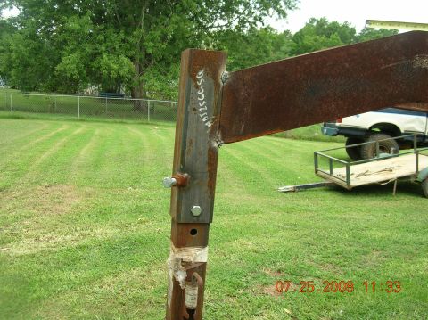 1991 Ford F-150 - A trailer hitch is attached to a vehicle, seen from a side angle with a fence post in the foreground.