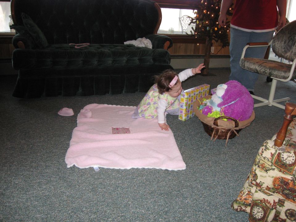 Baby reaching for a gift basket with a purple stuffed animal