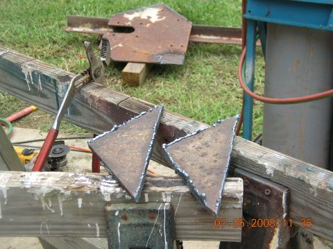 1991 Ford F-150 - Two freshly cut metal pieces rest on wooden supports, with tools and a gas cylinder visible in the background.