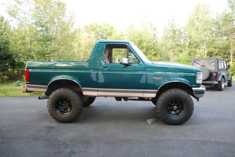 1996 Ford Bronco - Photograph of a green lifted Ford Bronco with a Jeep behind it, not a technical document.