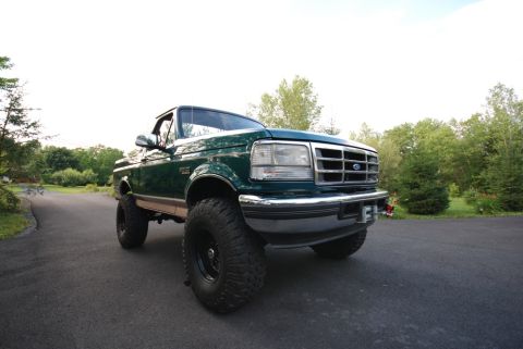 1996 Ford Bronco - Photograph of a green lifted Ford Bronco parked outdoors, not a technical document.