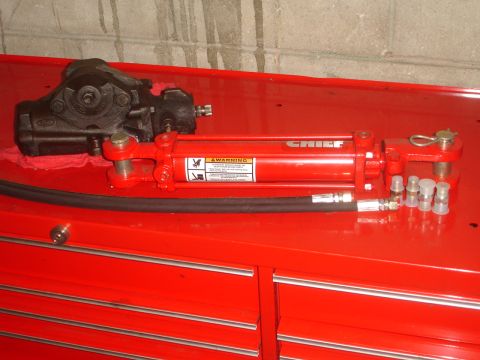1989 Ford Bronco - Power steering gearbox and hydraulic cylinder assembly shown on a red toolbox.