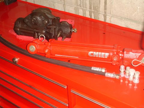1989 Ford Bronco - Power steering components, including a steering gear box and a hydraulic cylinder, are laid out on a red tool chest.