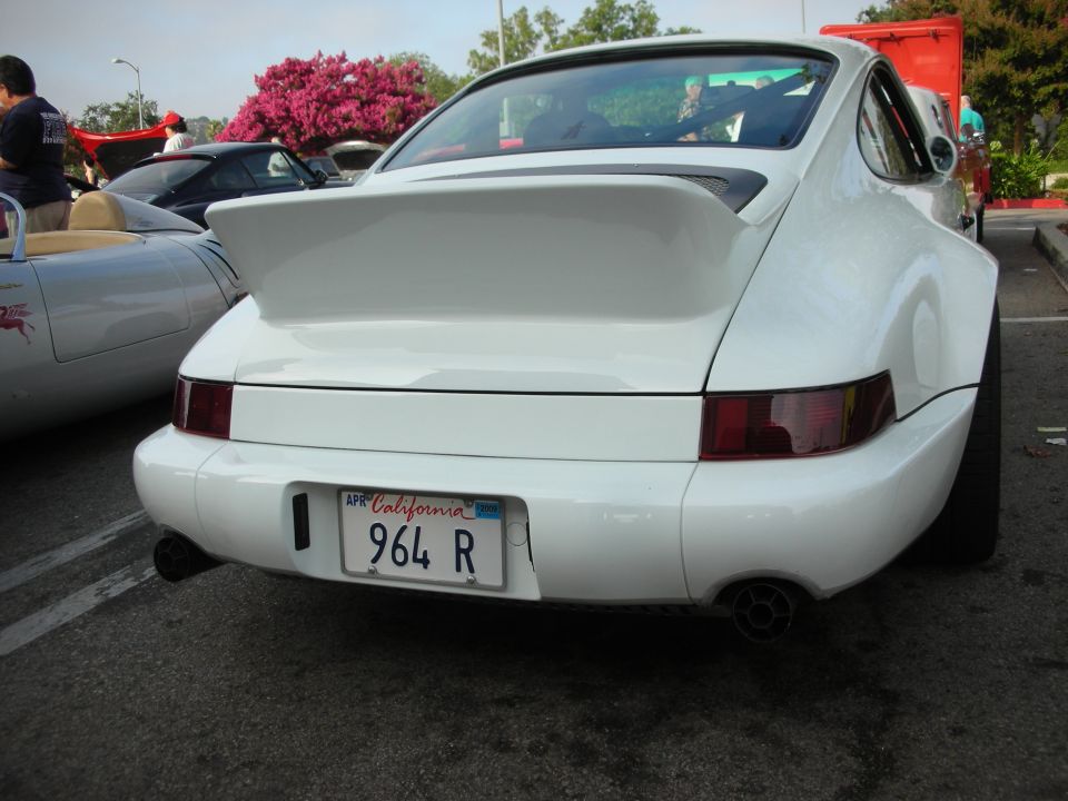 Rear view of a white Porsche 911 (964) with a large whale-tail spoiler
