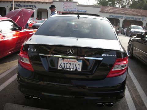 1998 Ford Crown Victoria - Photograph of the rear of a black Mercedes-Benz C63 AMG sedan at an outdoor car meet.