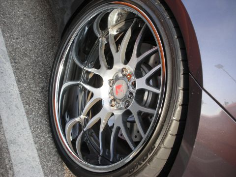1998 Ford Crown Victoria - Photograph of a vehicle's chrome multi-spoke alloy wheel and low-profile tire, not a technical document.
