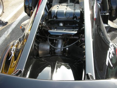 1998 Ford Crown Victoria - rear-mounted motorcycle engine of a black T-Rex three-wheeler showing a black cone air filter.