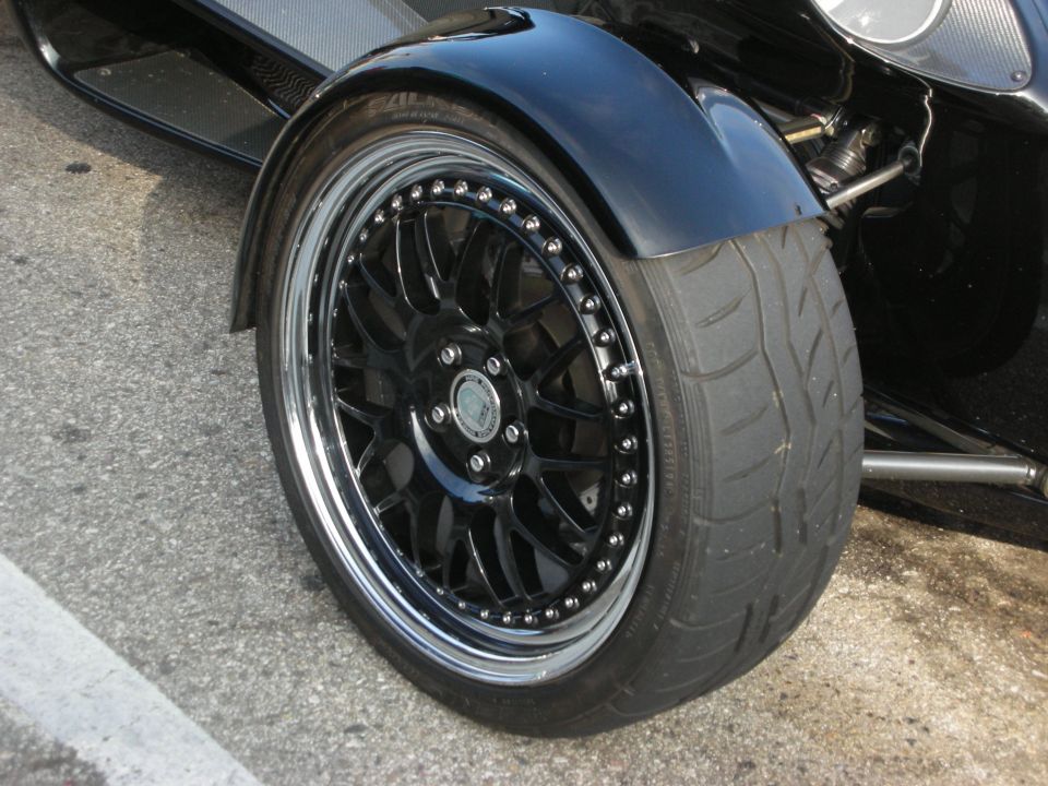 Close-up of black multi-spoke wheel and tire on a vehicle