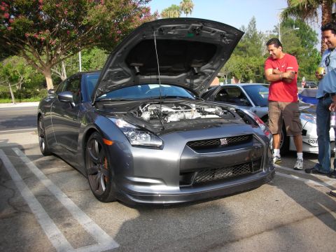 1998 Ford Crown Victoria - Photograph of a gray Nissan GT-R with hood raised at an outdoor car meet, not a technical document.