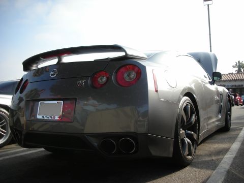 1998 Ford Crown Victoria - Photograph of a gray Nissan GT-R from the rear quarter at a car meet, not a technical document.