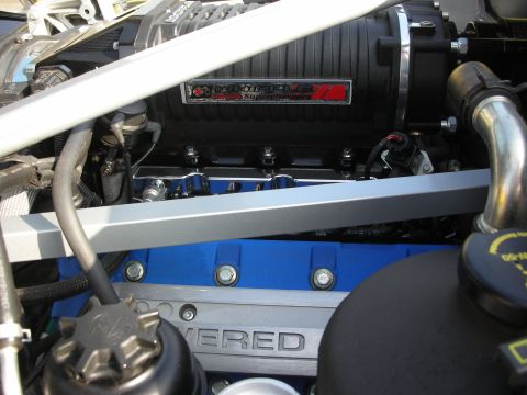 1998 Ford Crown Victoria - Photograph of a Whipple supercharger and engine cover in a car's engine bay, not a technical document.