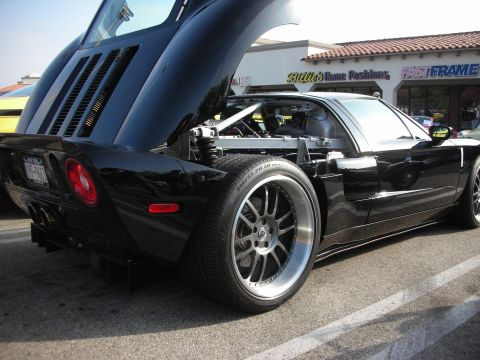 1998 Ford Crown Victoria - Photograph of a black Ford GT with rear clamshell raised at a car meet, not a technical document.