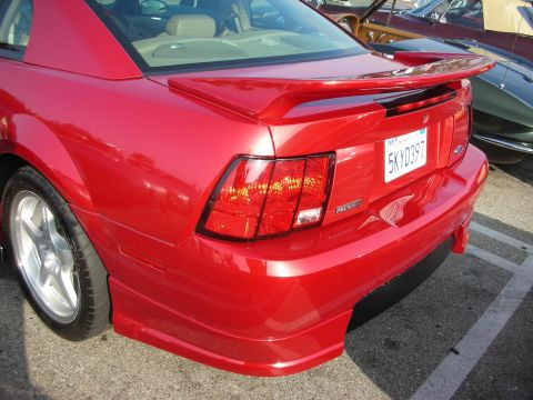 1998 Ford Crown Victoria - Photograph of the rear quarter of a red Roush Mustang with body kit and California license plate, not a technical document.