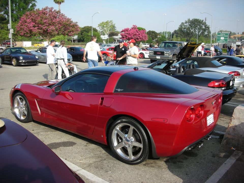 Rear three-quarter view of a red C6 Corvette at a car meet