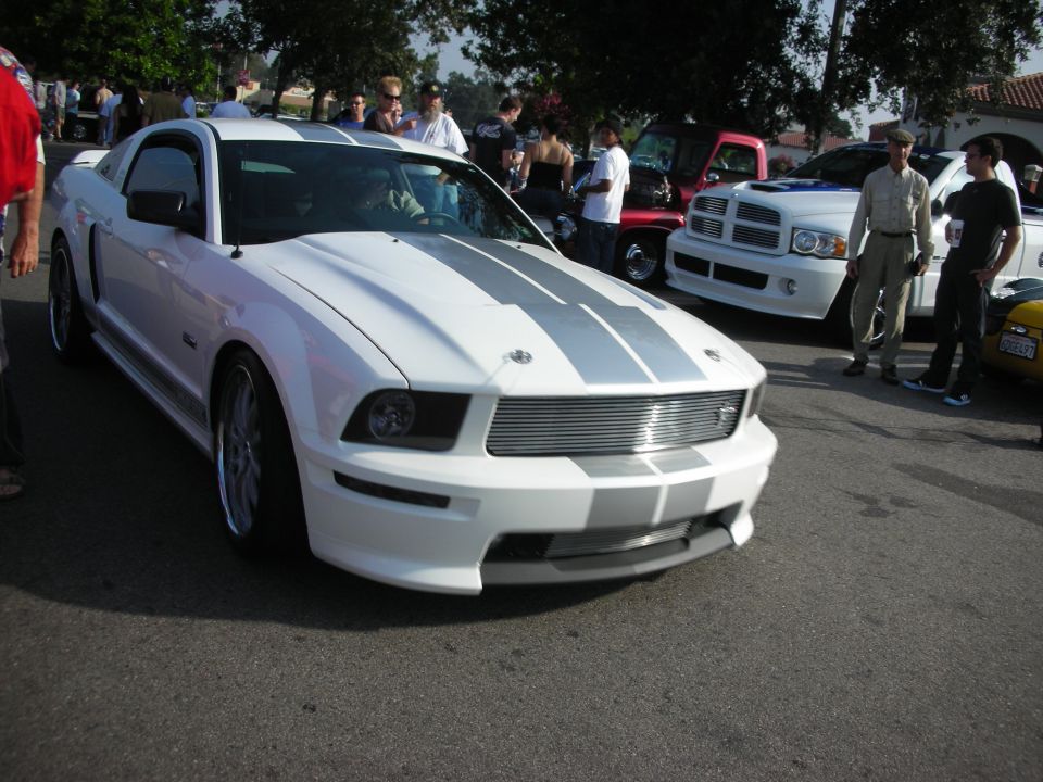 White Shelby Mustang GT at a car show with onlookers