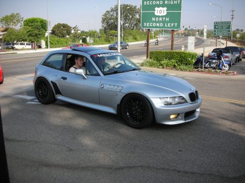 1998 Ford Crown Victoria - Photograph of a silver BMW Z3 coupe near a freeway sign, not a technical document.