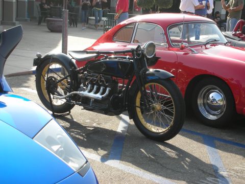 1998 Ford Crown Victoria - Photograph of a vintage motorcycle and a red classic sports car in a parking lot, not a technical document.