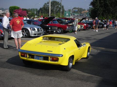 1998 Ford Crown Victoria - Rear view of a yellow Lotus Europa among a row of classic cars and spectators.