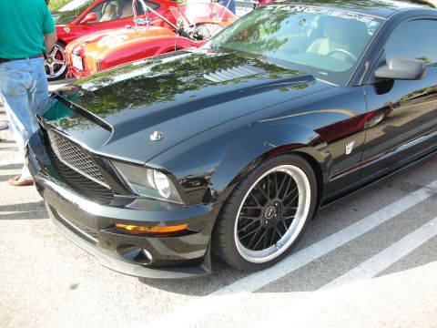 1998 Ford Crown Victoria - Photograph of a black Shelby Mustang front fender and black wheel, not a technical document.