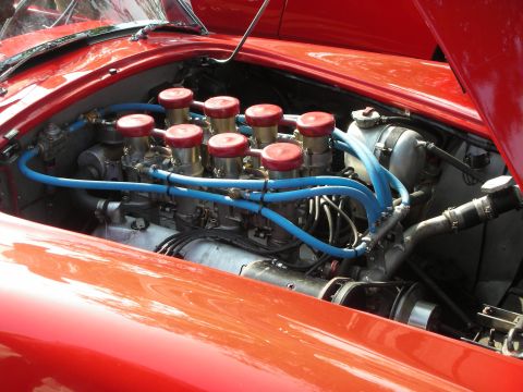 1998 Ford Crown Victoria - Photograph of a red car's engine bay with multiple carburetors and blue fuel lines, not a technical document.