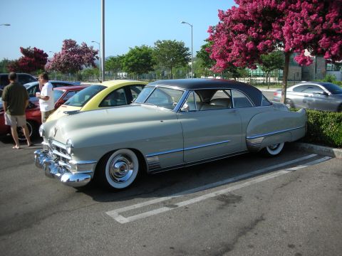 1998 Ford Crown Victoria - Photograph of a two-tone vintage Cadillac at an outdoor car gathering, not a technical document.