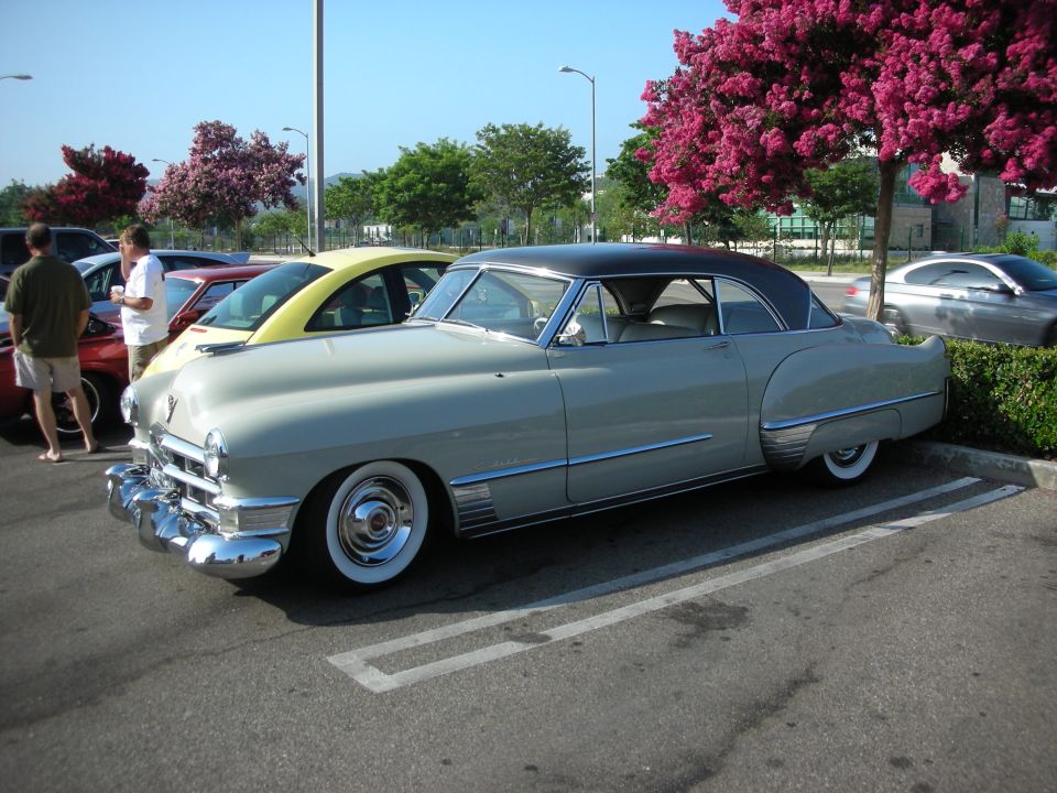 Two-tone vintage Cadillac coupe side view in a parking lot