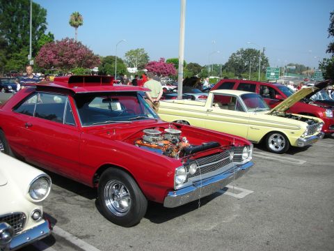 1998 Ford Crown Victoria - Photograph of a red Dodge Dart muscle car with its hood open at a car gathering, not a technical document.