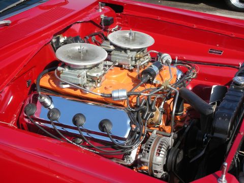 1998 Ford Crown Victoria - Photograph of a red car's engine bay with dual carburetors on an orange-painted V8, not a technical document.