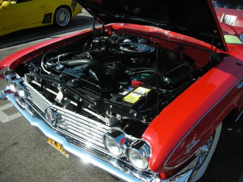 1998 Ford Crown Victoria - Photograph of a red vintage car's engine compartment with the hood open, not a technical document.