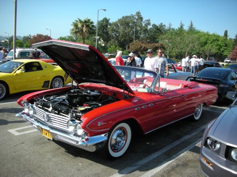 1998 Ford Crown Victoria - Photograph of a red early-1960s Buick convertible displayed at a car show, not a technical document.