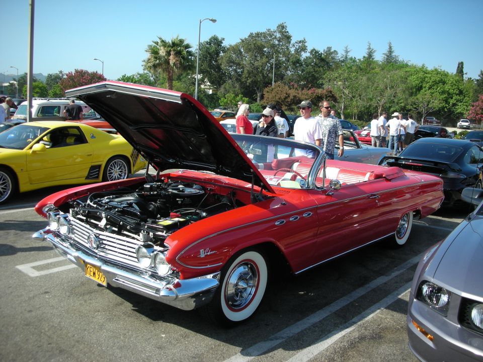 Red Buick convertible with hood open at an outdoor car show