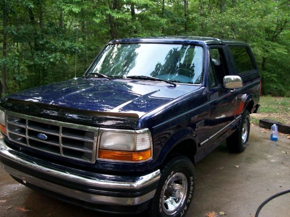 Dark blue 1992 Ford Bronco with chrome grille and bumper, parked outdoors