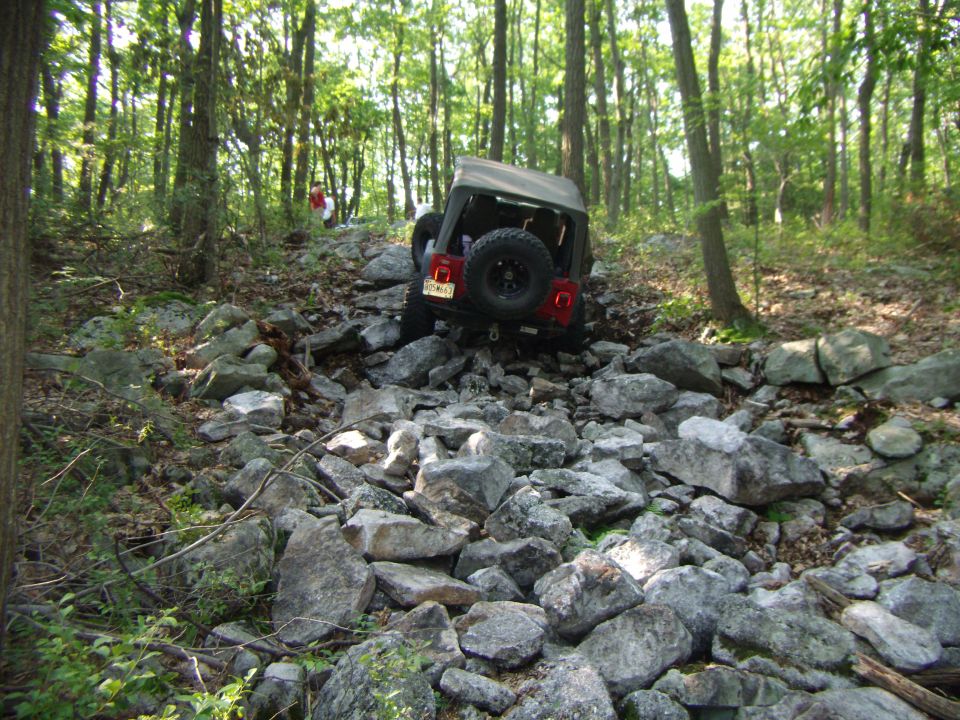 Red 2003 Jeep Wrangler on rocky trail