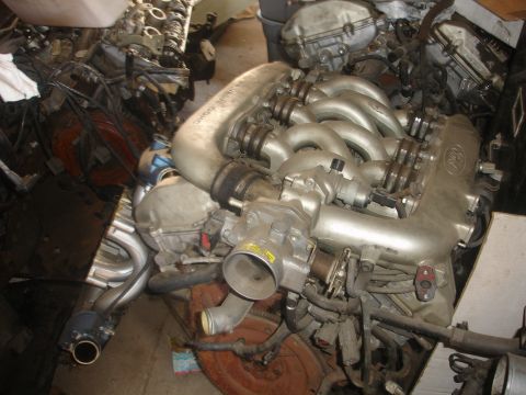 1993 Ford Taurus - Engine from a Ford vehicle, possibly a 1993 model, shown in a parts storage area.