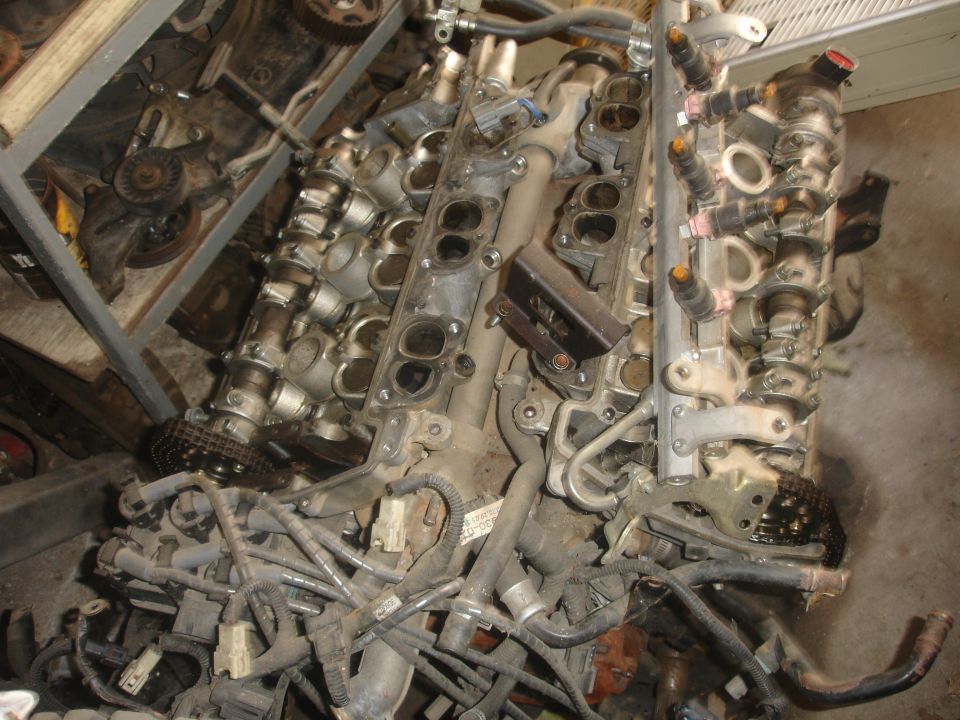 Engine assembly with fuel injectors and intake manifold visible. Some wiring and hoses are attached