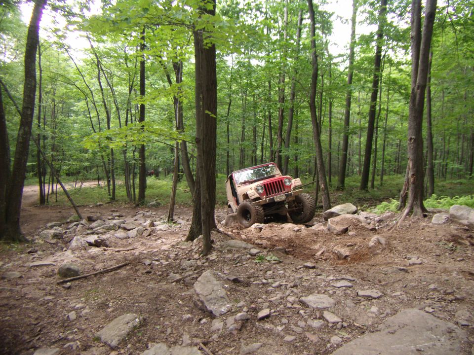 2003 Jeep Wrangler navigating a rocky forest trail