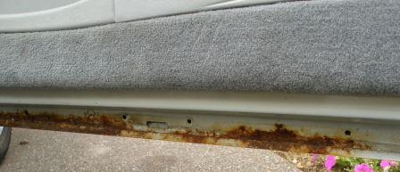 1998 Lincoln Mark VIII - Significant rust is visible along the rocker panel of the vehicle's door sill.