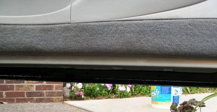 1998 Lincoln Mark VIII - Car door sill area showing carpeted trim and the underside of the vehicle.