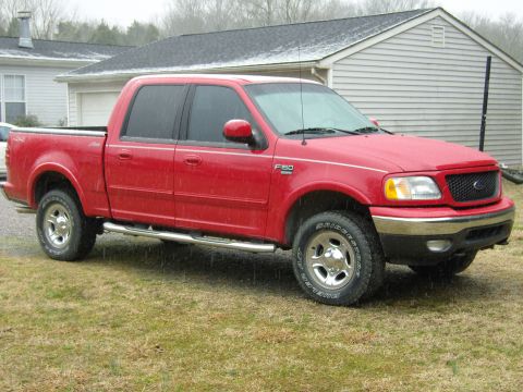 2007 Ford Mustang - Photograph of a red Ford F-150 crew-cab pickup shown in side profile on a wet lawn.