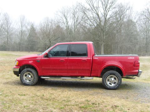 2007 Ford Mustang - Photograph of a red Ford F-150 crew-cab pickup in side profile on a grassy field.