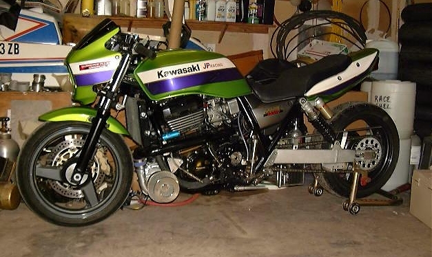 Green and purple Kawasaki naked motorcycle, left side, in a garage