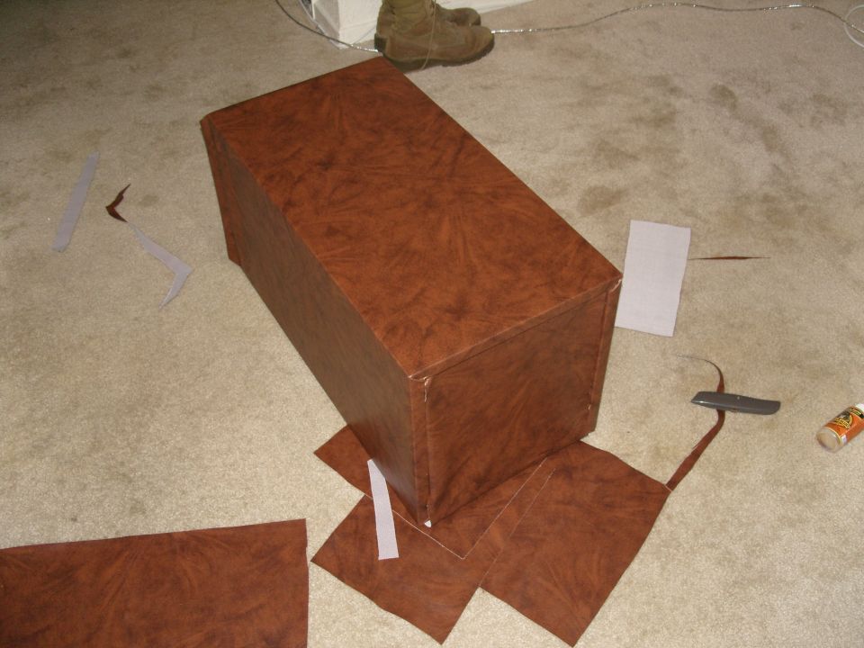 Brown box on carpet with scattered brown material and glue.