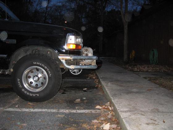 Black Ford Bronco front end with aftermarket bumper. Tire is visible