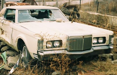1969 Lincoln III - This 1969 Lincoln III is in a state of disrepair, with a shattered windshield and visible body damage.