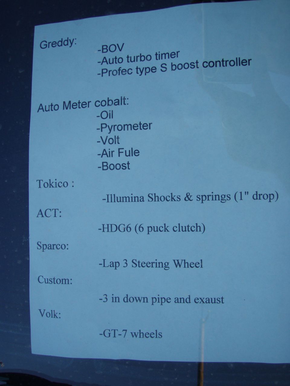 A document listing car parts from brands like Greddy, Auto Meter, Tokico, ACT, Sparco, and Volk.