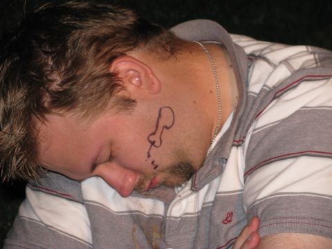 2003 Ford Focus - A man is sleeping with a drawing on his cheek. He is wearing a striped shirt.