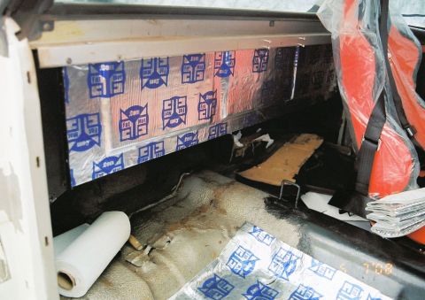 1976 Ford Ranchero - The interior shows sound dampening material being applied to the walls and floor, with orange seats visible.