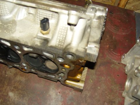 2007 Ford Mustang - Photograph of a partially disassembled engine cylinder head resting on a bench.