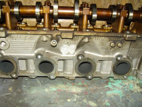 2007 Ford Mustang - Photograph of an engine cylinder head showing camshaft, intake ports and casting marks.