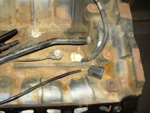 2007 Ford Mustang - Photograph of an engine block underside showing an oil pickup tube and electrical connectors, not a technical document.